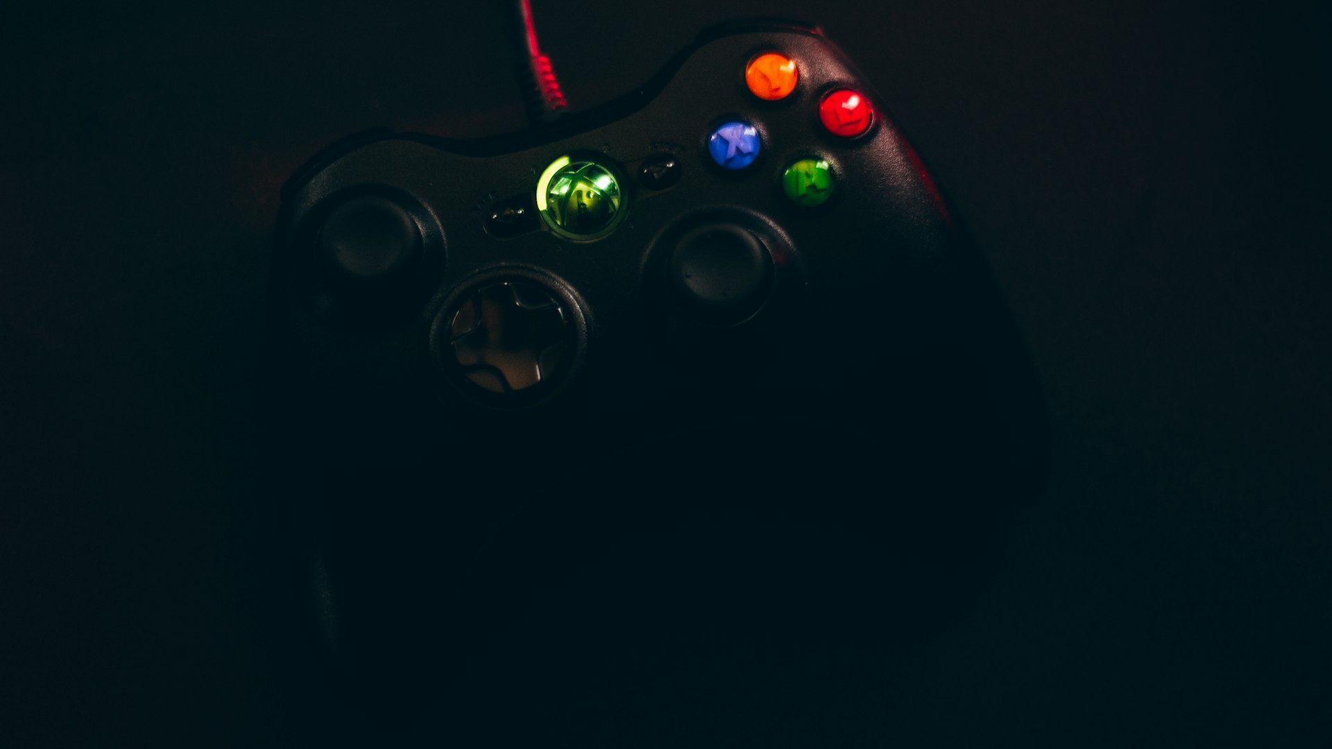Dark neon game controller lit against a wall